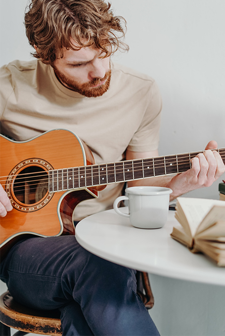 man plays guitar and practises a learning method